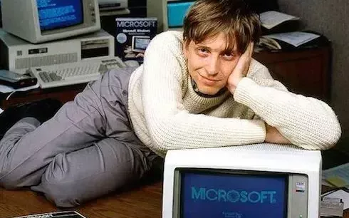 An image of a young Bill Gates sitting at a computer with the early MS-DOS interface. (famous entrepreneurs and their business)

